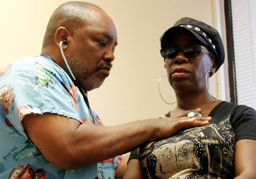 Male nurse checking a woman's heart rate